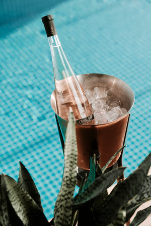 une bouteille de vin rosé obelo provence posée au bord d'une piscine
