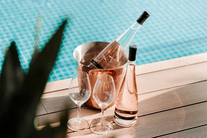 une bouteille de vin rosé obelo posé au bord d'une piscine