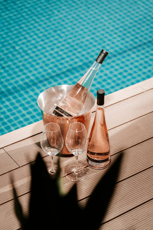 des bouteilles de vin rosé obelo provence posées au bord d'une piscine